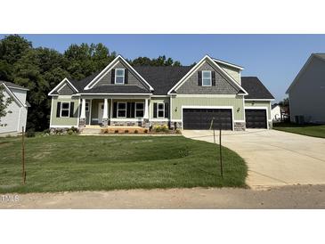 Charming home with a black roof, three-car garage, and well-maintained lawn in a suburban neighborhood at 111 Hot Springs Way, Benson, NC 27504