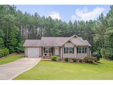 Charming single-story home with manicured lawn, attached garage, and welcoming front porch at 1210 Bayview Ct, Franklinton, NC 27525