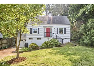 Charming home boasts a well-manicured lawn, bright red door, and attached garage at 1516 Edgevale Rd, Durham, NC 27701