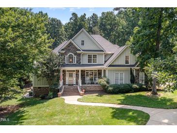 Charming two-story home with stone accents, covered porch, and beautifully landscaped front yard at 2012 Silverleaf Dr, Youngsville, NC 27596
