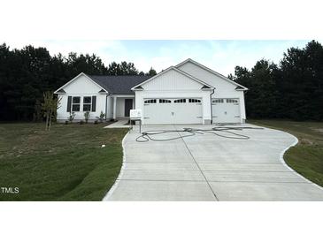 Charming single-story home with white siding, a spacious driveway, and a two-car garage at 295 Eason Creek Way, Clayton, NC 27527