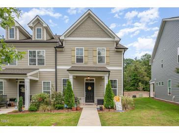 Charming two-story townhouse with a well-manicured lawn and inviting front porch at 321 Conrad Ln, Wake Forest, NC 27587