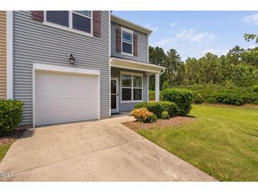 Charming two-story home featuring a one car garage, manicured lawn, and welcoming front porch at 3417 Cardinal Lake Dr, Durham, NC 27704
