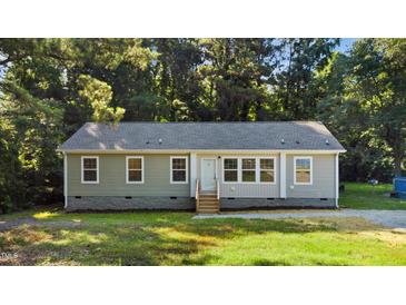 Charming single-story home with light green siding, gray roof, and inviting front entrance surrounded by lush trees at 41 Andrea Ct, Sanford, NC 27332