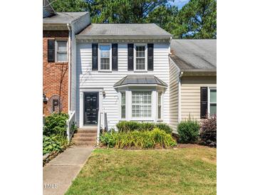 Charming townhouse with black shutters, a bay window, and manicured front lawn at 6051 Epping Forest Dr, Raleigh, NC 27613