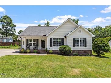 Charming single-Gathering home with a manicured lawn, covered porch, and traditional design elements at 65 Alcock Ln, Youngsville, NC 27596