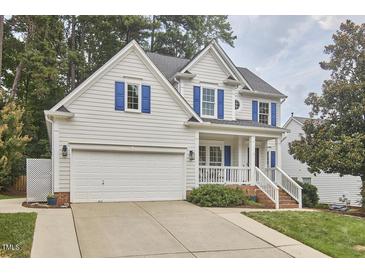 Charming two-story home featuring a two-car garage, blue shutters, and manicured landscaping at 102 Duxbury Dr, Cary, NC 27513