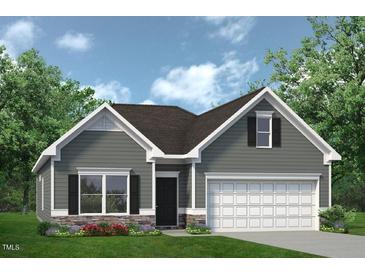 Charming single-story home featuring a two-car garage, stone accents, and well-manicured landscaping at 104 E American Marigold Dr, Benson, NC 27504