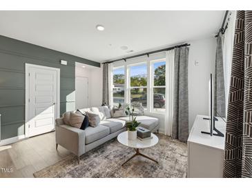 Bright living room boasts a large sectional sofa, decorative rug and an abundance of natural light at 1224 S Person St # 101, Raleigh, NC 27601