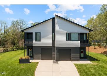 Contemporary duplex with a well-manicured lawn and modern design elements including individual 1-car garages at 2201 Millbank Village Ct # 101, Raleigh, NC 27610