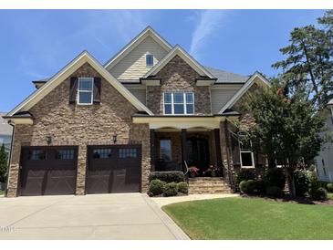 Beautiful brick home with a two-car garage, manicured lawn, and mature landscaping at 2725 Belmont View Loop, Cary, NC 27519