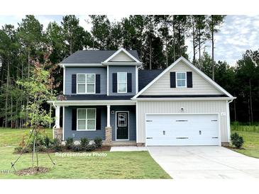 Charming two-story home with a well-maintained lawn and a two-car garage at 348 Danube Dr, Zebulon, NC 27597