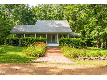Charming home featuring a brick walkway and a well-maintained front yard with lush greenery at 3506 Arthur Minnis Rd, Hillsborough, NC 27278