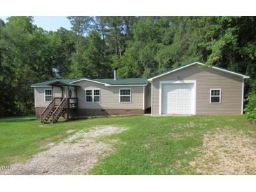 Charming single-story home with a metal roof, front porch, and an attached one-car garage on a sunny day at 440 Montgomery Rd, Franklinton, NC 27525