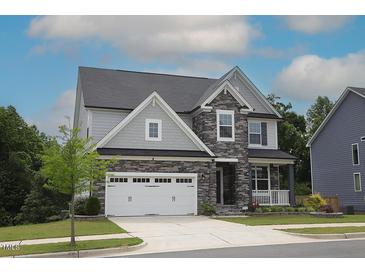 Charming two-story home featuring stone accents, a two-car garage, and a well-maintained lawn at 4416 Walker Hallow St, Raleigh, NC 27616