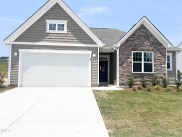 Charming home featuring stone and neutral siding with a bright white garage door at 67 Furley St., Homesite 117, Sanford, NC 27330