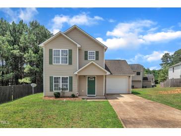Charming two-story home with a well-manicured lawn, attached garage, and inviting curb appeal at 71 Herndon Ct, Clayton, NC 27520
