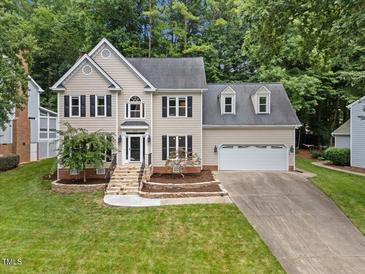 Charming two-story home with well-manicured lawn, attached two car garage, and a stone walkway leading to the front door at 7808 Sandy Bottom Way, Raleigh, NC 27613