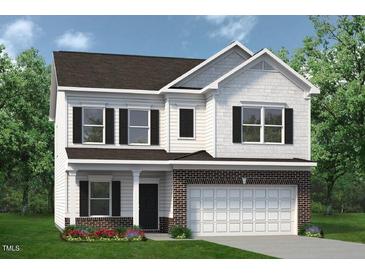 Charming two-story home features a brick and white exterior, complemented by a well-manicured lawn and lush landscaping at 108 Freedom Heights Ln # 147, Smithfield, NC 27577