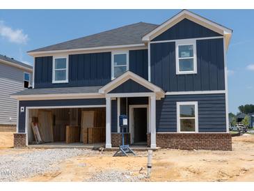 Two story home featuring a blue exterior, white trim and an attached garage awaiting finishing touches at 1233 Whitespire Way, Zebulon, NC 27597