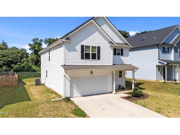 Charming two-story home with white siding, black shutters, attached garage, and well-maintained lawn at 12658 W Hanes Ave, Middlesex, NC 27557