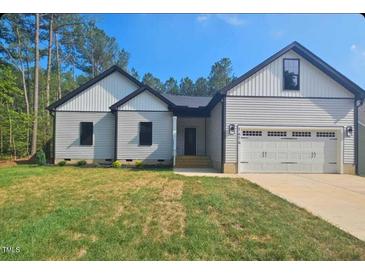 Charming one-story home with attached garage, landscaped yard, and inviting front porch at 1414 Sagamore Dr, Louisburg, NC 27549