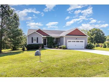 Charming single-story home with a well-manicured lawn and two car garage at 20 Ingate Way, Louisburg, NC 27549