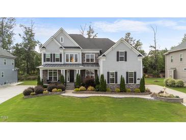 A charming two-story home with gray siding, black shutters, and a beautifully landscaped front yard at 228 Cloverdale Rd, Apex, NC 27523
