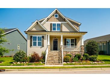 Charming home featuring a welcoming front porch with stone accents and manicured landscaping at 262 Salt Cedar Ln, Chapel Hill, NC 27516