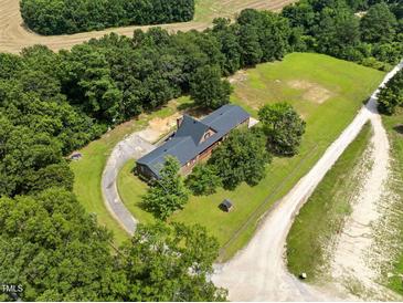 Aerial view showcases wooded property with a long driveway and a traditional home at 3129 Tarheel Clubhouse Road Rd, Raleigh, NC 27604