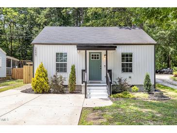 Charming home featuring a well maintained lawn, a cozy porch, and a modern white exterior at 3649 Guess Rd, Durham, NC 27705