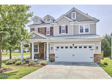 Charming two-story home featuring a manicured lawn and a two-car garage at 418 Magna Dr, Durham, NC 27703