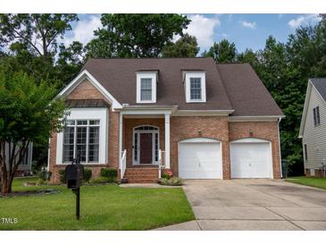 Charming two-story brick home with attached two-car garage and manicured front lawn at 5818 Myakka Ct, Raleigh, NC 27616