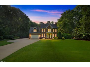 Stunning two-story brick home with manicured lawn and attached garage at 7713 Summercrest Dr, Apex, NC 27539