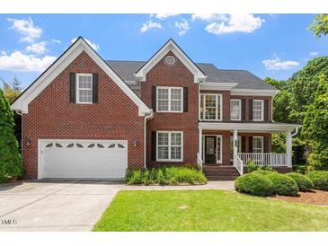 Charming two-story brick home featuring a manicured lawn and attached two-car garage at 1153 Litchborough Way, Wake Forest, NC 27587