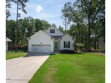 Charming single-Gathering home featuring a well-manicured lawn and attached two-car garage at 133 Black Cloud Dr, Louisburg, NC 27549