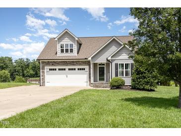 Charming gray two-story home with stone accents, a two-car garage, and a well-manicured front lawn at 14 Water Front Ln, Timberlake, NC 27583