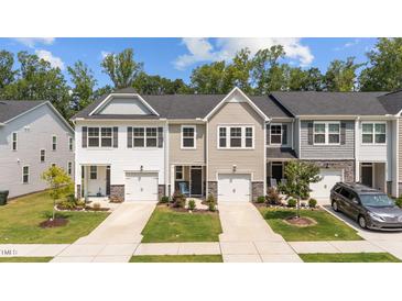 Charming townhomes with single-car garages, manicured lawns, and stone accents create an inviting curb appeal at 156 Velvet Ridge Way, Garner, NC 27529