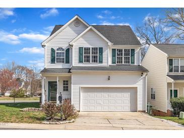 Charming two-story home boasts a white exterior, well-manicured lawn, and attached garage, perfect for comfortable living at 1968 Shadow Glen Dr, Raleigh, NC 27604