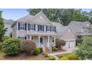 Charming two-story home with blue shutters, manicured lawn, and attached two-car garage at 2420 Rogerson St, Raleigh, NC 27614