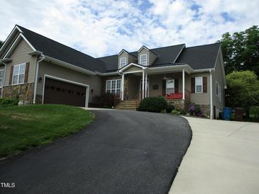 Charming home featuring stone accents, dormer windows, an attached garage, and a cozy front porch at 3008 River Hill Ln, Burlington, NC 27217