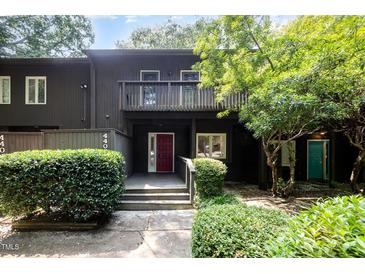 Inviting two-story townhome with a red front door, balcony, and lush greenery at 4403 Sunburst Ct, Raleigh, NC 27613