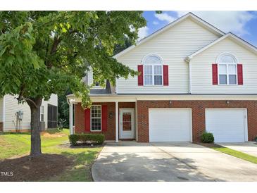 Charming townhome with a brick facade, a two-car garage, and a well-maintained front yard at 617 Woodson Dr, Clayton, NC 27527