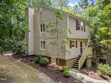 Inviting two-story home featuring red shutters and a chimney, nestled among lush greenery at 6422 English Oaks Dr, Raleigh, NC 27615