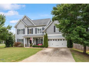 Charming two-story home with a well-manicured lawn, gray siding, and attached two car garage at 6901 Rex Rd, Holly Springs, NC 27540