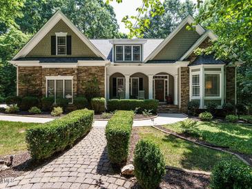 Charming stone and shake home with manicured landscaping and inviting front porch at 8504 Carlton Oaks Dr, Wake Forest, NC 27587