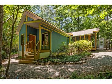 Charming blue and yellow home featuring a wooden porch and gravel driveway at 9709 Greenfield Rd, Chapel Hill, NC 27516