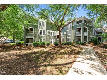 Green, multi-story condo building with mature trees in a well-maintained complex at 1010 Nicholwood Dr # 301, Raleigh, NC 27605