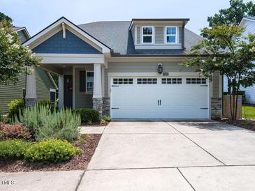Charming home featuring an attached two car garage and meticulously landscaped front yard at 12421 Angel Vale Pl, Durham, NC 27703