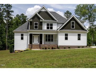 Charming two-story home with white siding, dark trim, and inviting front porch at 190 Whistlers Cv, Louisburg, NC 27549